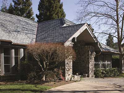 Front view of a home with stone siding and American Slate gray tiles on its roof