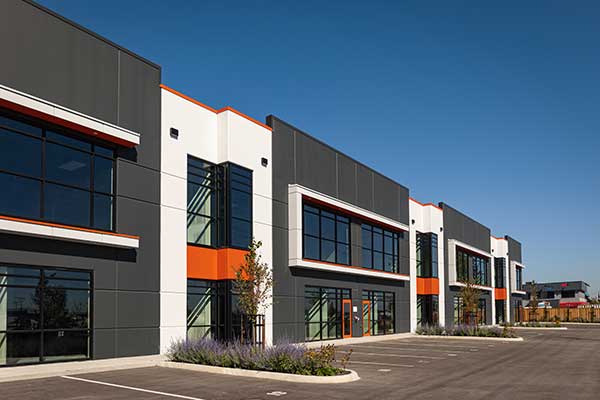Large commercial building with different businesses painted with an alternating white and dark gray color